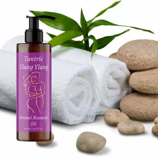 a bottle of tanning massage oil next to a pile of rocks and a bamboo