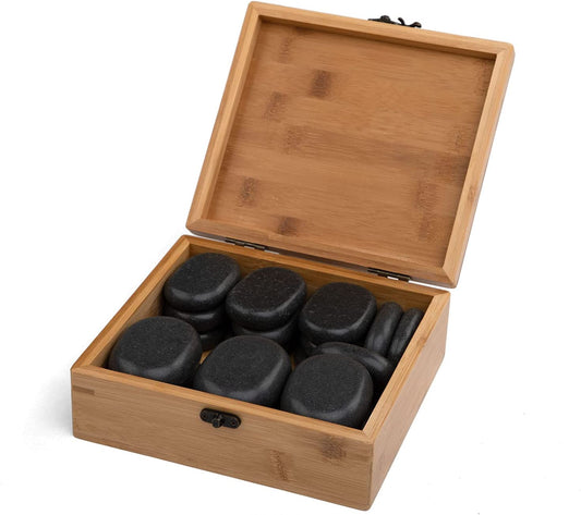 a wooden box filled with black rocks on a white background