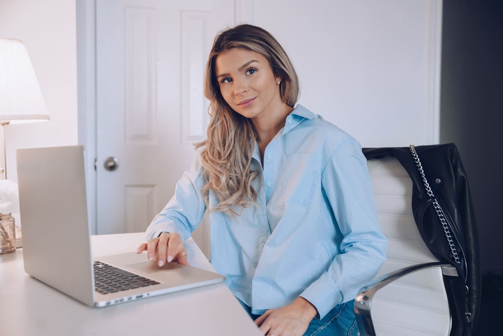 Junge Frau im Home-office arbeite am Laptop und sucht eine Geschenk für Ihre Freundin