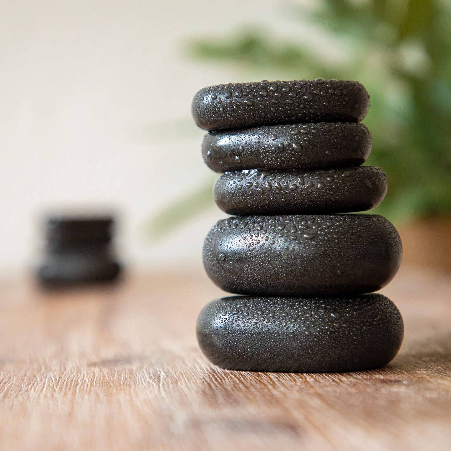 a stack of black rocks sitting on top of a wooden table