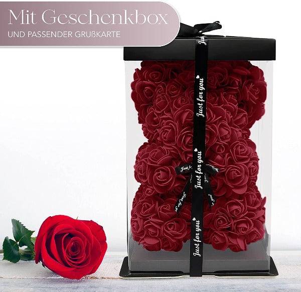 a red rose in a clear box with a black ribbon